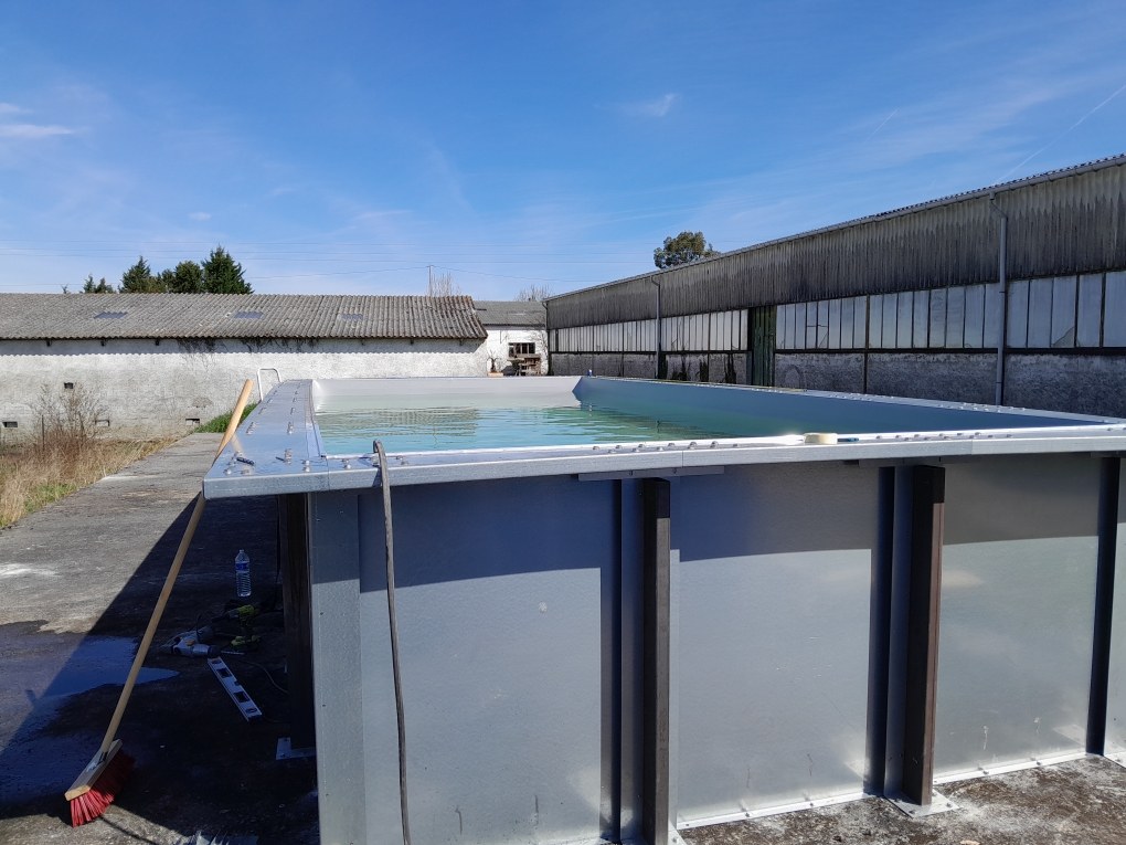 Piscine à panneaux métalliques montée et remplie d'eau