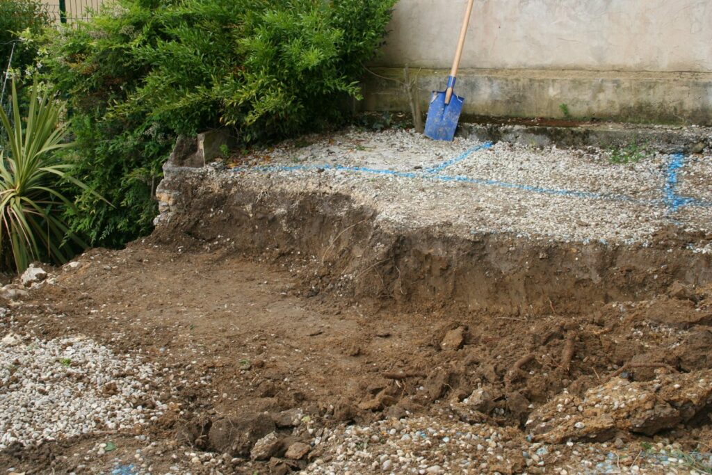 Terrassement à la main, implantation tracée à la bombe