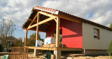 Extension ossature bois avec terrasse couverte et bardage rouge