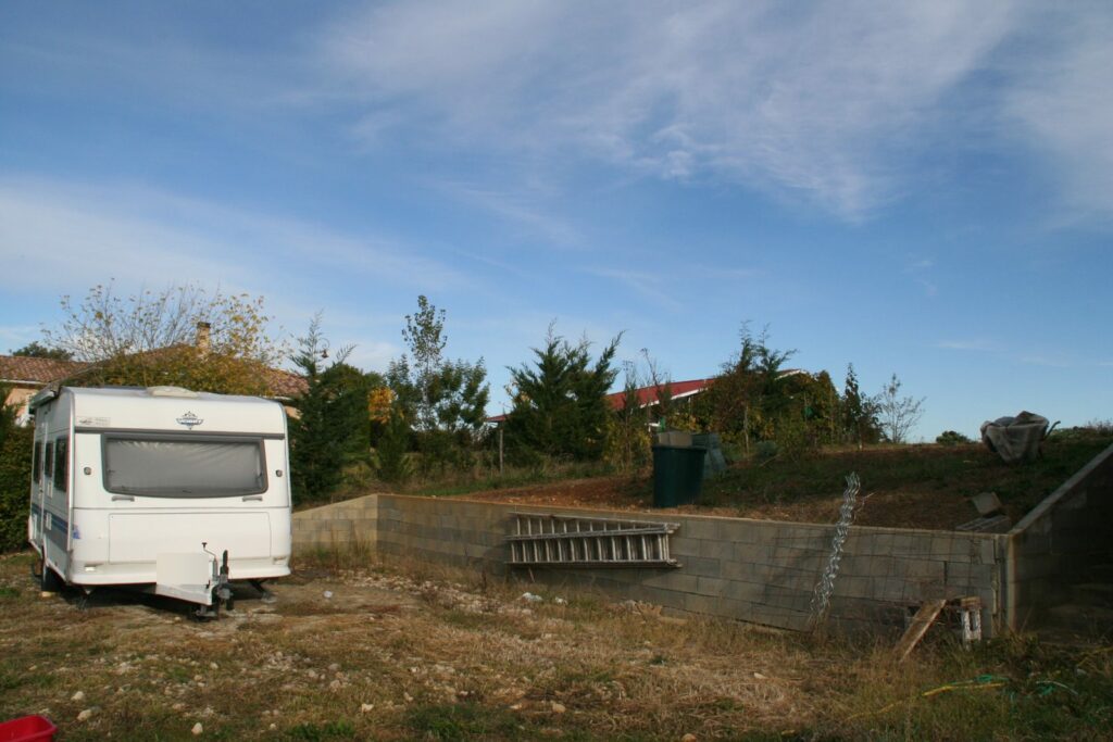 Terrain en pente avant travaux, muret de soutènement en parpaing