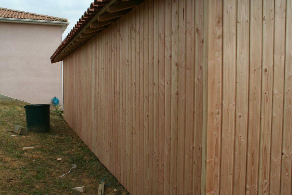 Long pan du carport en bardage bois