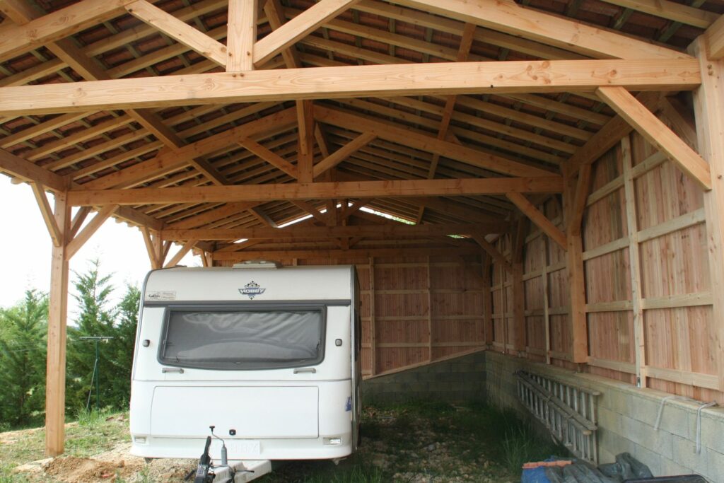 Caravane à l'abri sous le carport en bois