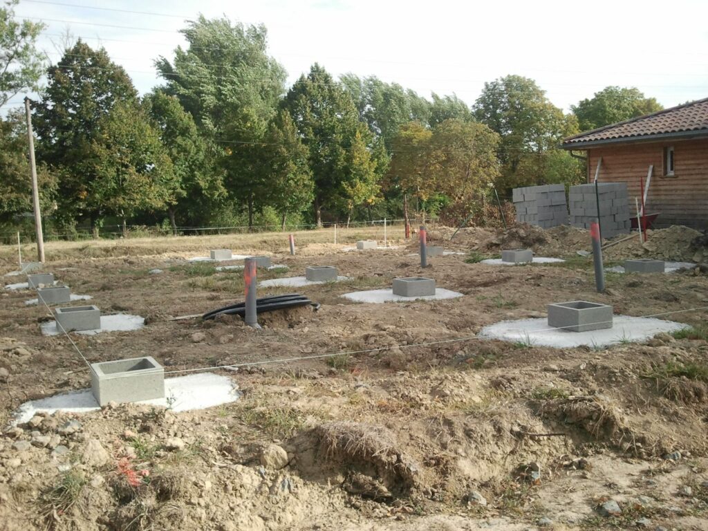 Plots en béton coulés pour les fondations ponctuelles d'une maison ossature bois