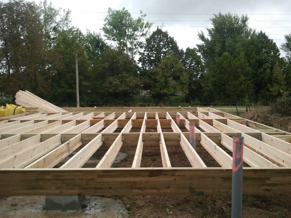 Solives du plancher bois posées sur le cadre de la maison