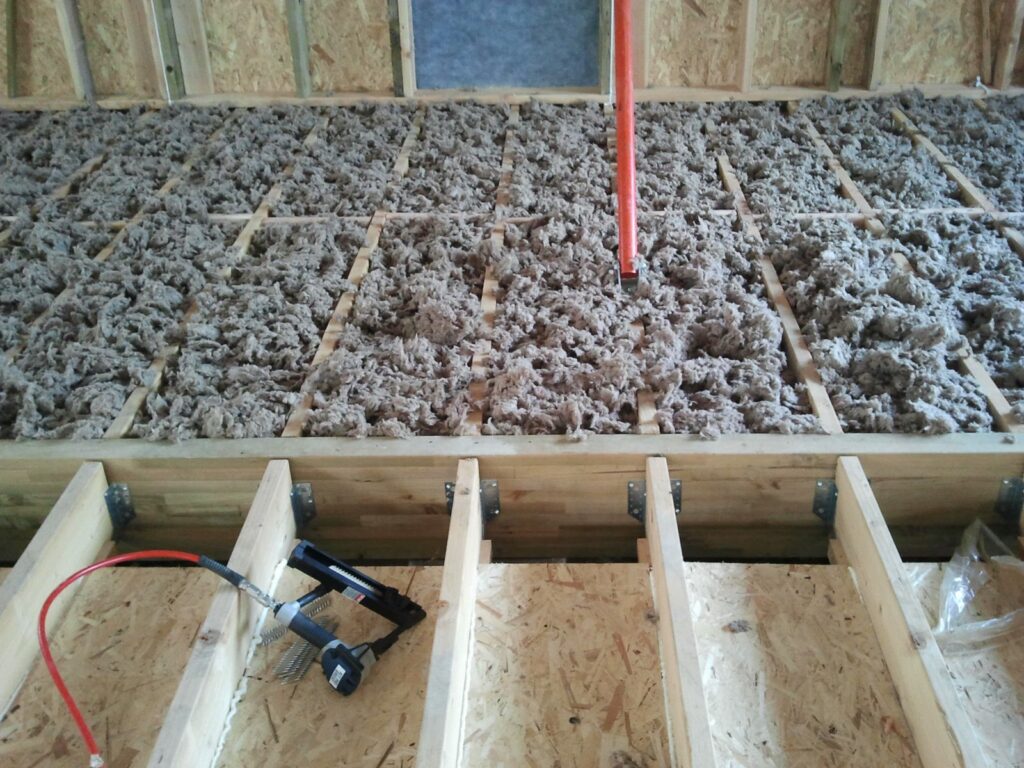 Isolant en flocons entre les solives du plancher bois