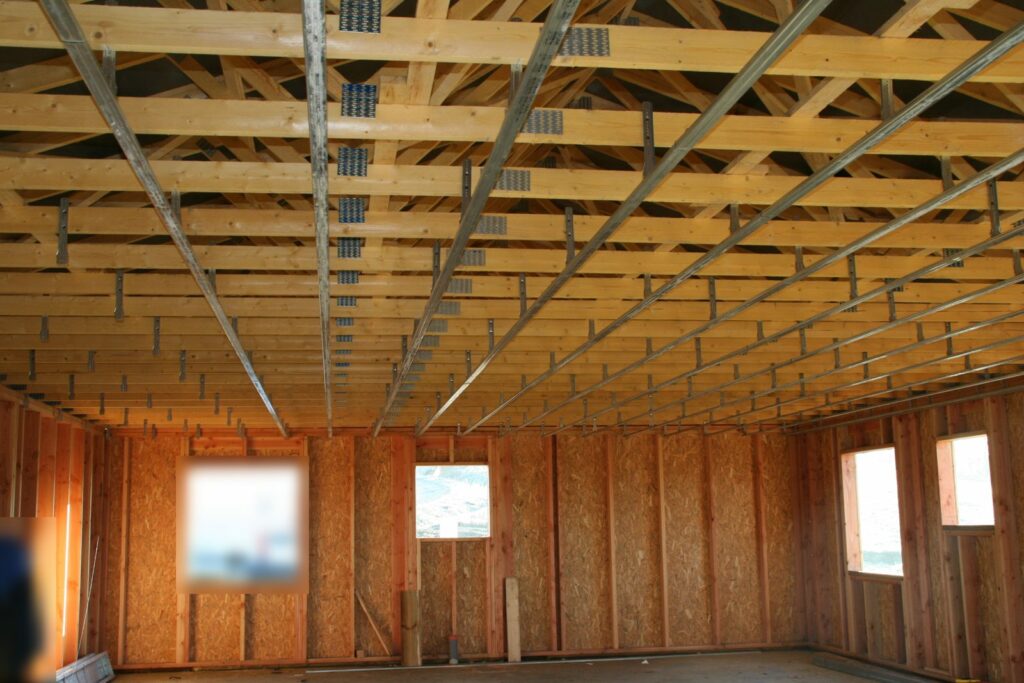 Charpente en fermettes industrielles vue de l'intérieur d'une maison bois