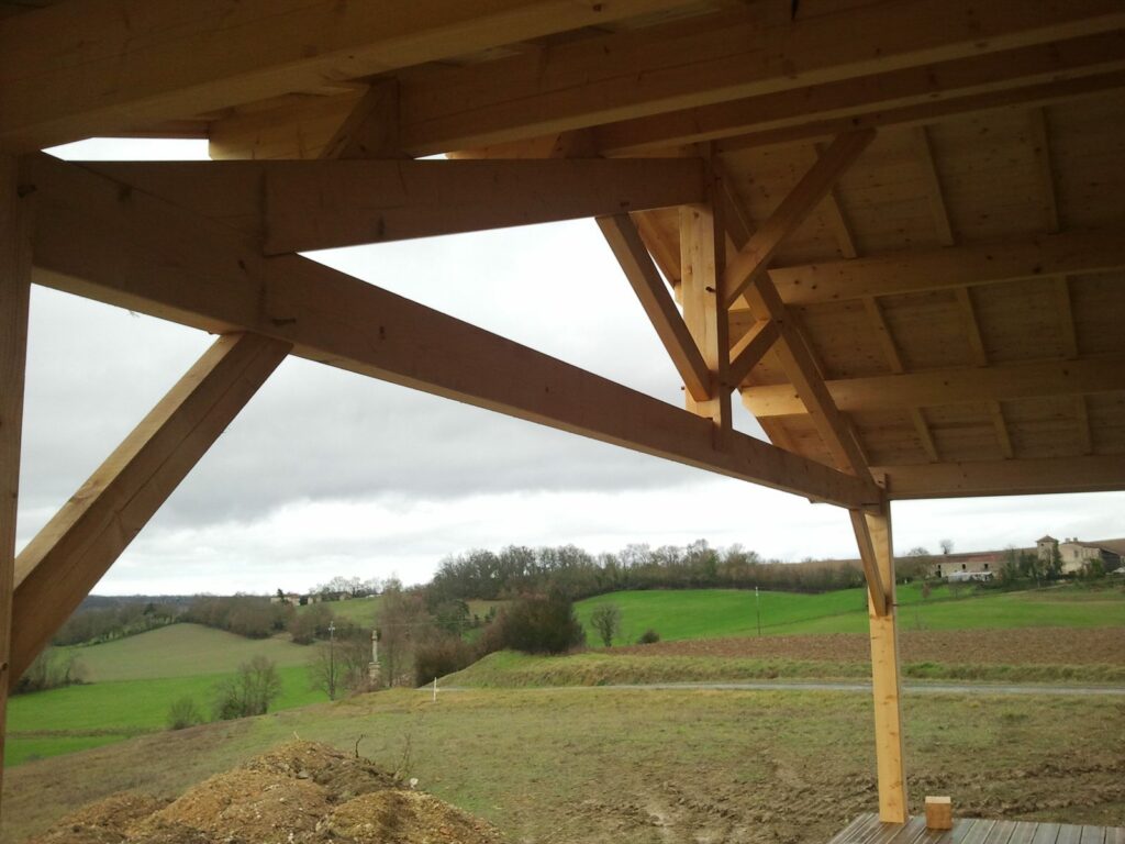 Porche en charpente traditionnelle apparente sur une maison bois
