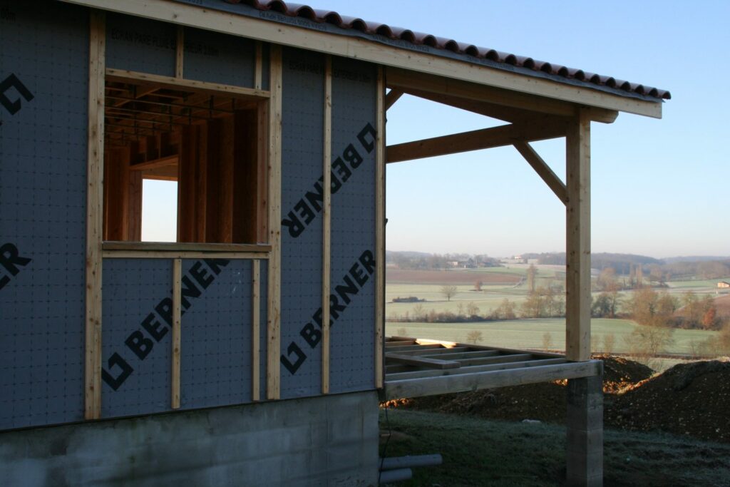 Porche couvert accolé au pignon d'une maison ossature bois