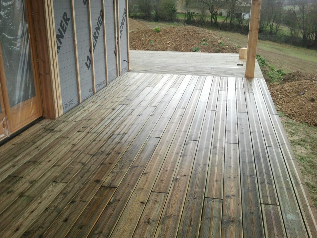 Angle de terrasse bois devant une maison ossature bois