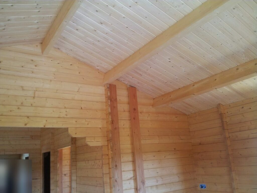 Plafond lambrissé sous rampant avec poutres apparentes