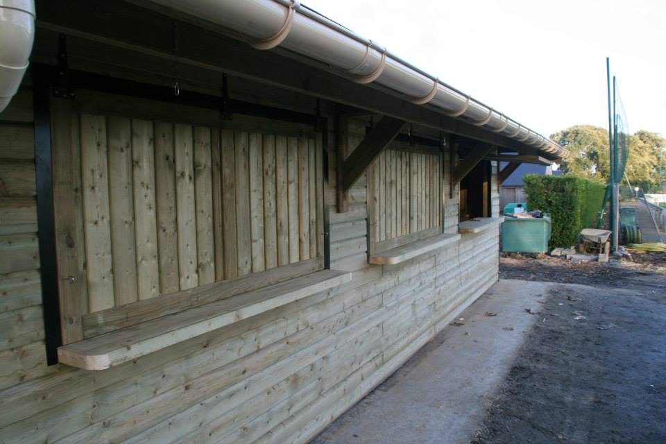 Comptoirs de service et volets bois sous le débord de toit