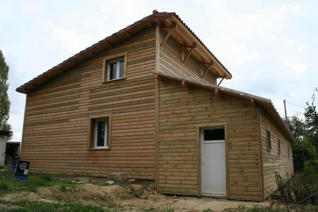 Maison en briques surélevée d'un étage en ossature bois, bardage horizontal
